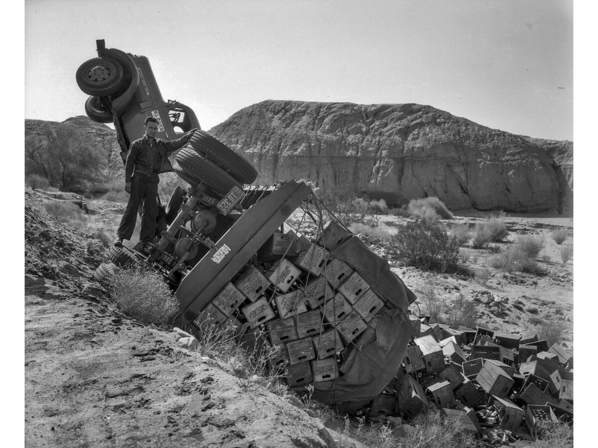 June 6, 1943: Driver E.L. Bohanon alongside his overturned truck on a highway between Indio and Desert Center.