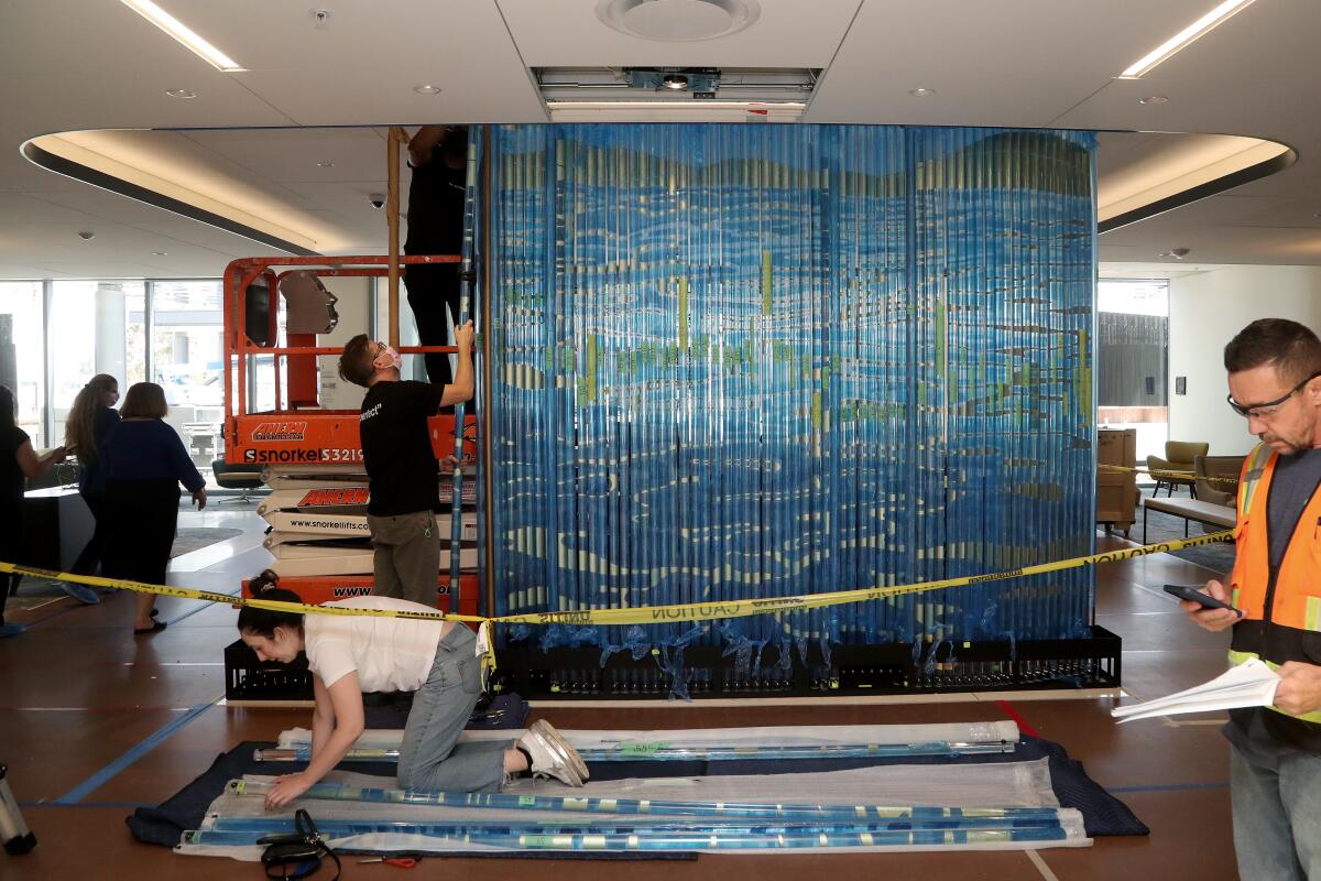 Workers assemble "Elemental," a 10-1/2-foot-tall artwork.
