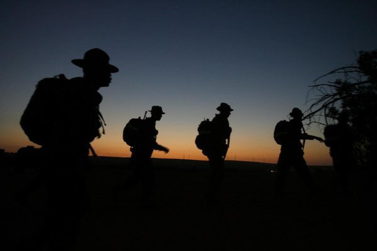 A Marine drill instructor shouts commands to a group of recruits during an early morning training exercise at Camp Pendleton in 2007.