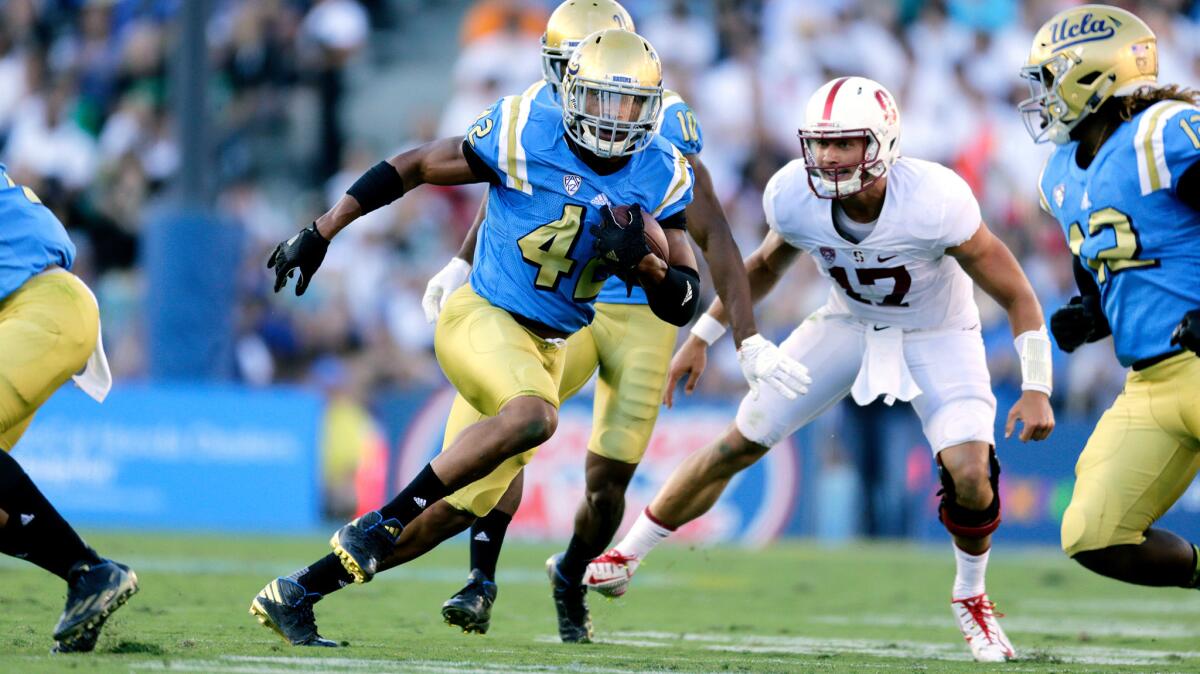 Kenny Young runs with the ball after picking off a pass by Stanford quarterback Ryan Burns on Sept. 24.