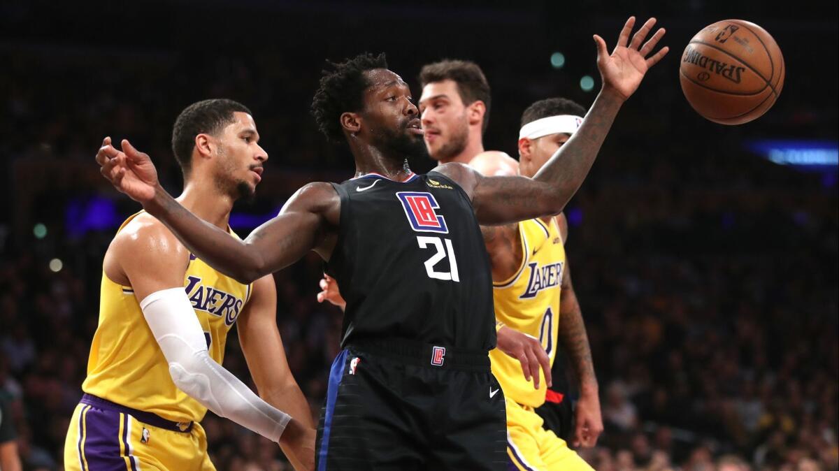 Patrick Beverley (21) of the Clippers reaches for a loose ball during the first half.