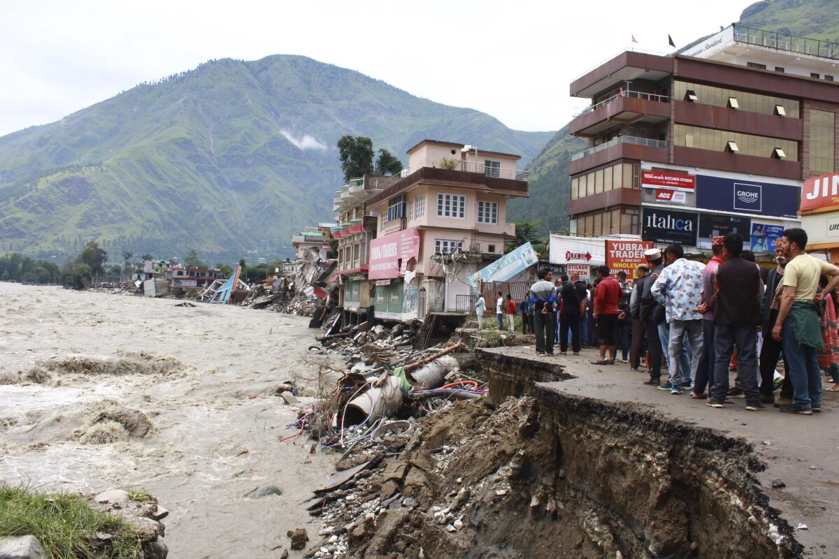 People standing by a washed-out road