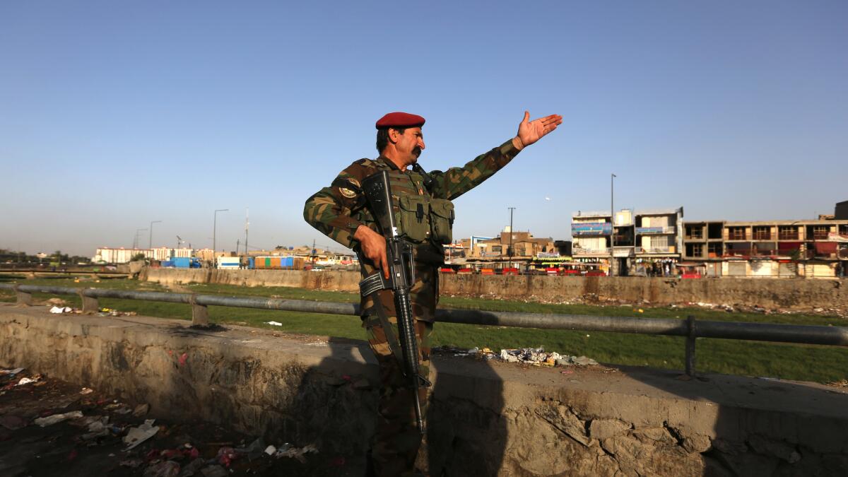 An Afghan soldier inspects the site of a suicide attack in Kabul near Afghanistan's Defense Ministry on Monday.