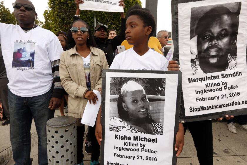 INGLEWOOD, CA - FEBRUARY 21, 2017 -- David Michael, father of Kisha Michael, from left, his daughter Trisha Michael, and Kisha's son Mikel Nicholson, 12, join other family and community members near the site where Kisha Michael and Marquintan Sandlin were shot and killed by police a year ago today in Inglewood on February 21, 2017. Michael and Sandlin, two single parents out on a date. who were unconscious when Inglewood police first responded to where they were sitting in a car on Manchester Blvd. in Inglewood. They were shot in their car by police. Police have released very little information about the shooting.(Genaro Molina / Los Angeles Times)