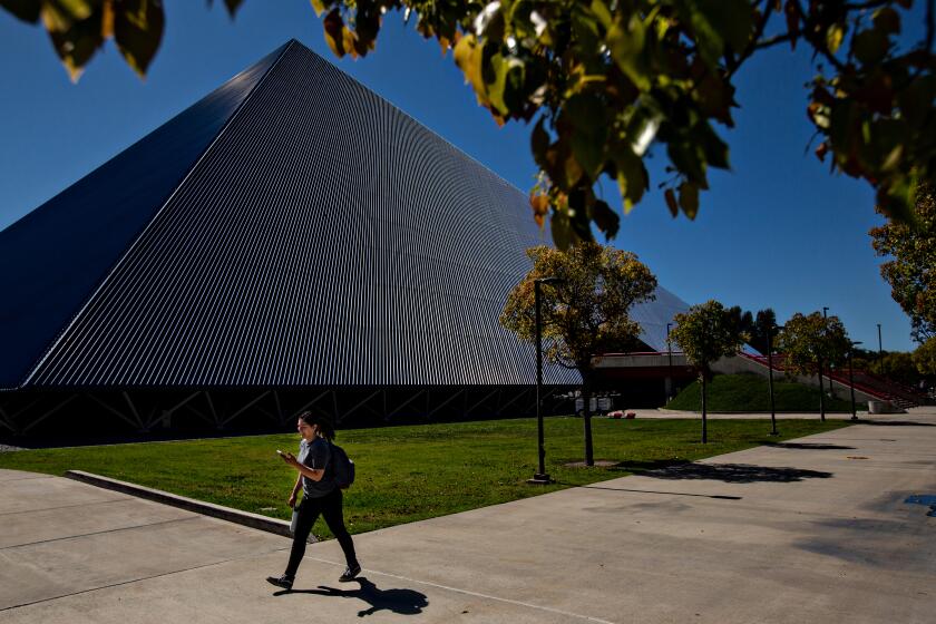 Long Beach, CA., March 11, 2020 - A student passes by The Walter Pyramid at Cal State Long Beach, where the campus has gone to online only classes on Tuesday, March 11, 2020 in Long Beach, California. (Jason Armond / Los Angeles Times)