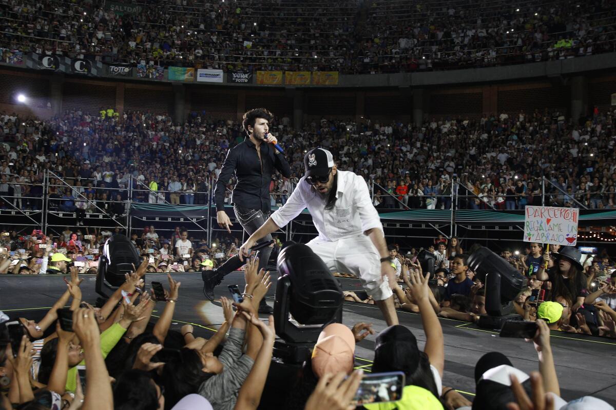 El cantante colombiano Sebastián Yatra (i) se presenta junto al puertorriqueño Dalmata (d) durante un concierto de la gira "Yatra Yatra Tour" en Medellín (Colombia).