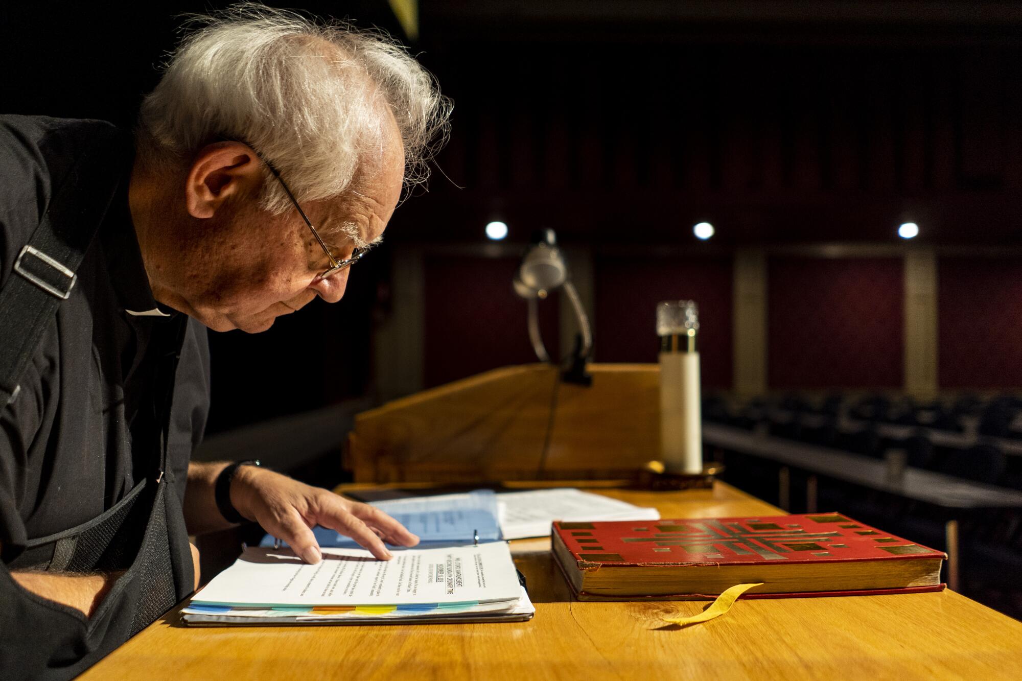 Father Charlie Urnick looks over his notes 