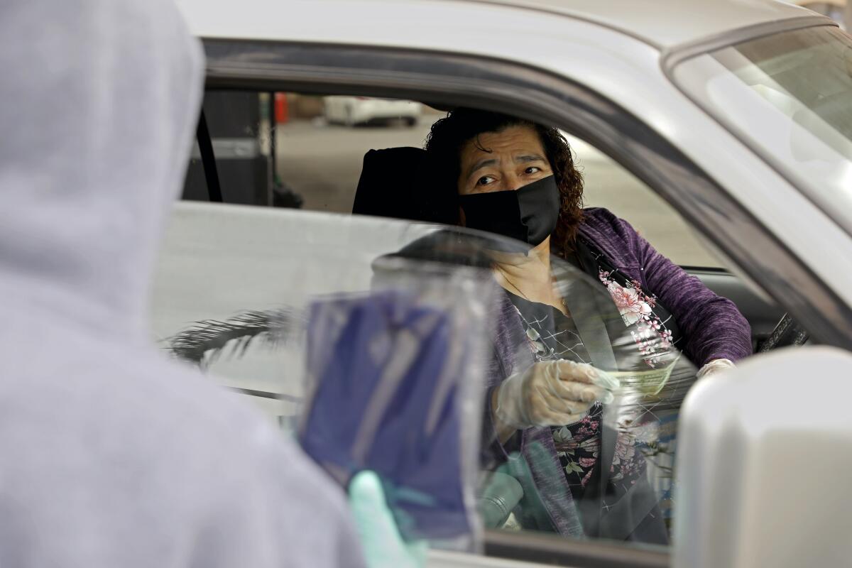 Carmen Murillo buys a mask from David Mendez on Prairie Avenue