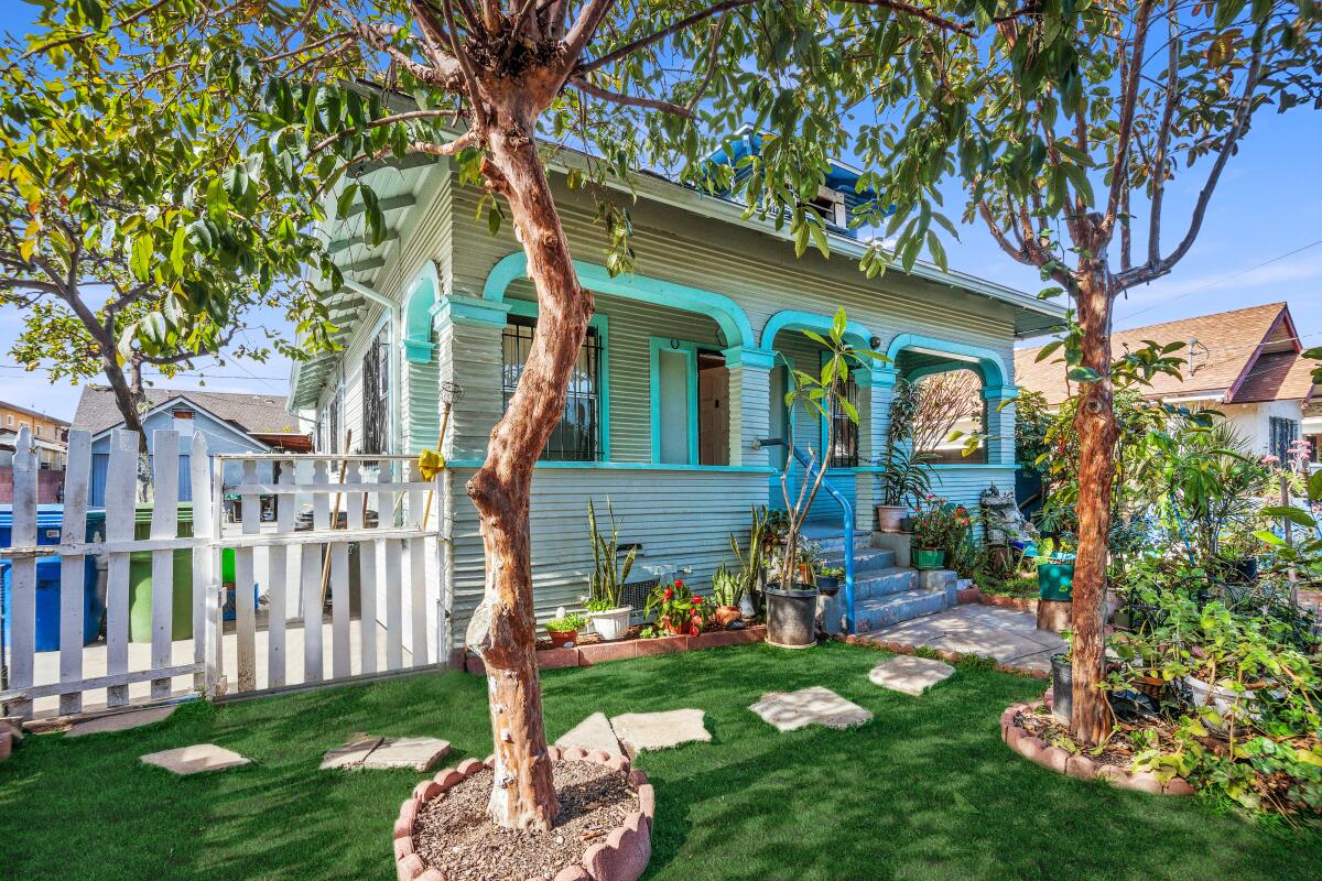 House with porch, two trees, picket fence