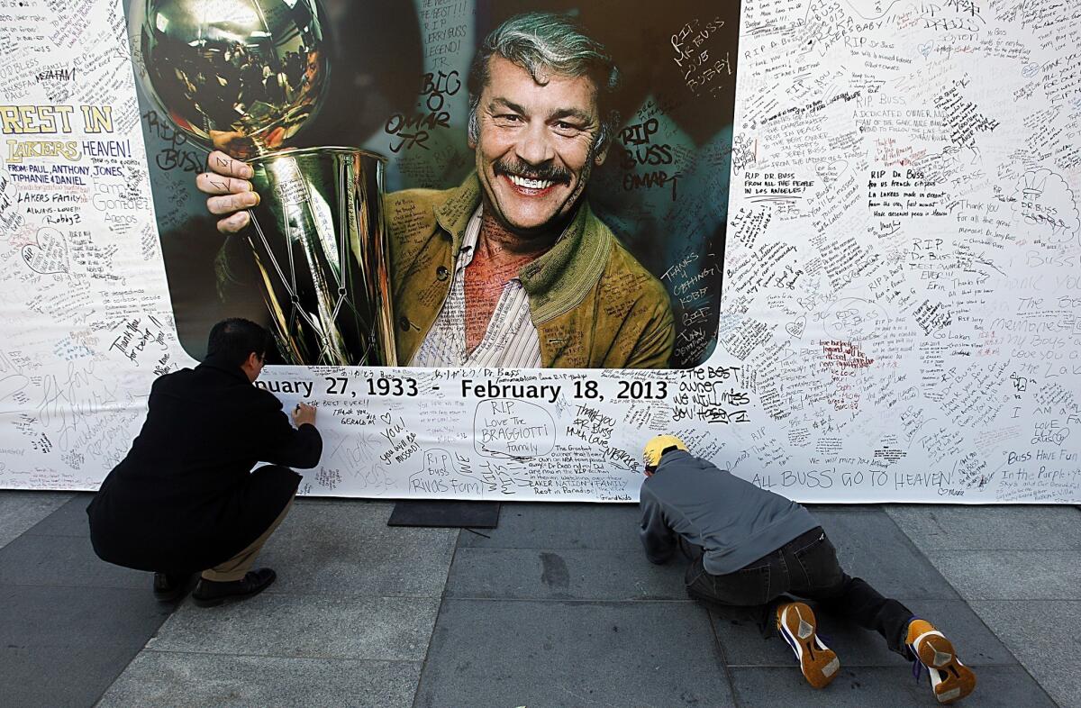 Fans write condolence messages on banners before a memorial service for Lakers owner Jerry Buss at the Nokia Theatre.
