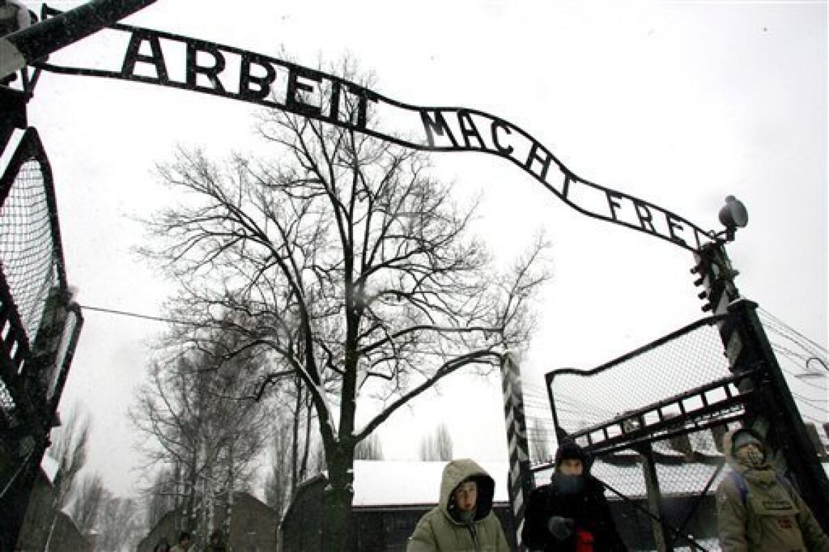 FILE - In this Jan. 26, 2005 file photo visitors walk through the entrance gate of the Auschwitz Nazi concentration camp in Oswiecim, southern Poland, a day before the commemorations of the 60th anniversary of the liberation of the Auschwitz Nazi concentration camp by Soviet troops. Polish police say the infamous iron sign over the gate to the Auschwitz memorial site with the cynical phrase "Arbeit Macht Frei" _ German for "Work Sets You Free" _ has been stolen. Police spokeswoman Katarzyna Padlo said police believe it was stolen between 3:30 a.m. and 5 a.m. Friday, Dec. 18, 2009, when museum guards noticed that it was missing and alerted police. (AP Photo/Herbert Knosowski, File)