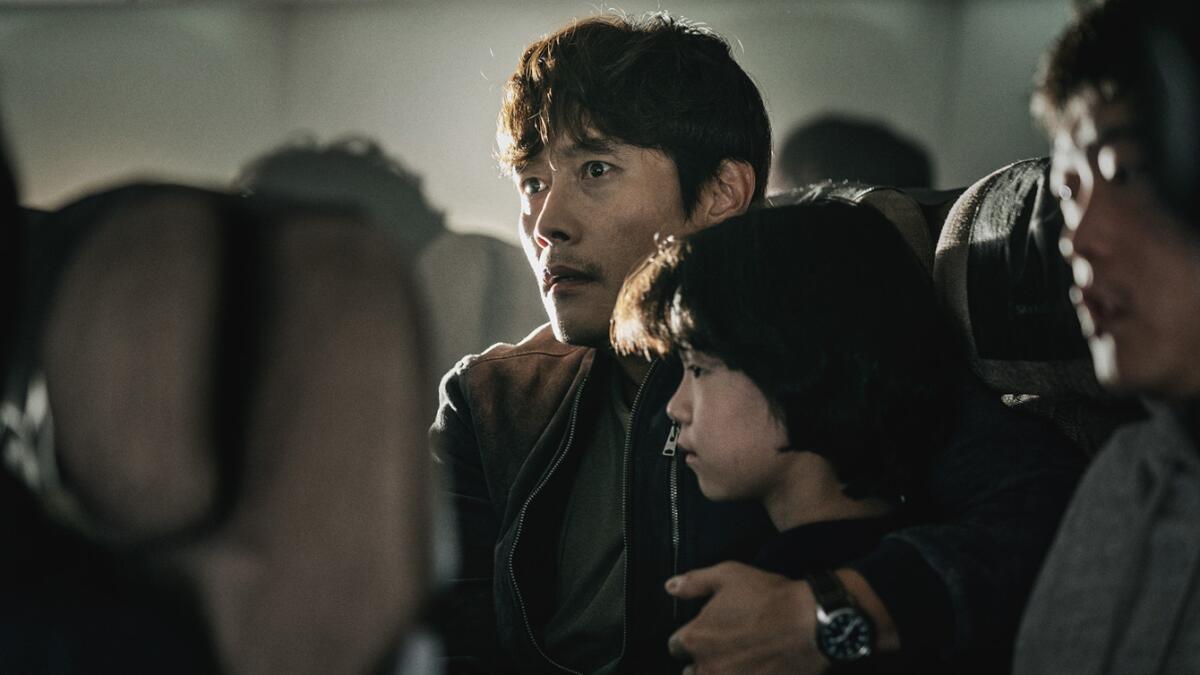 A Korean father holds his daughter as they are caught in a mid-flight disaster in the thriller "Emergency Declaration."