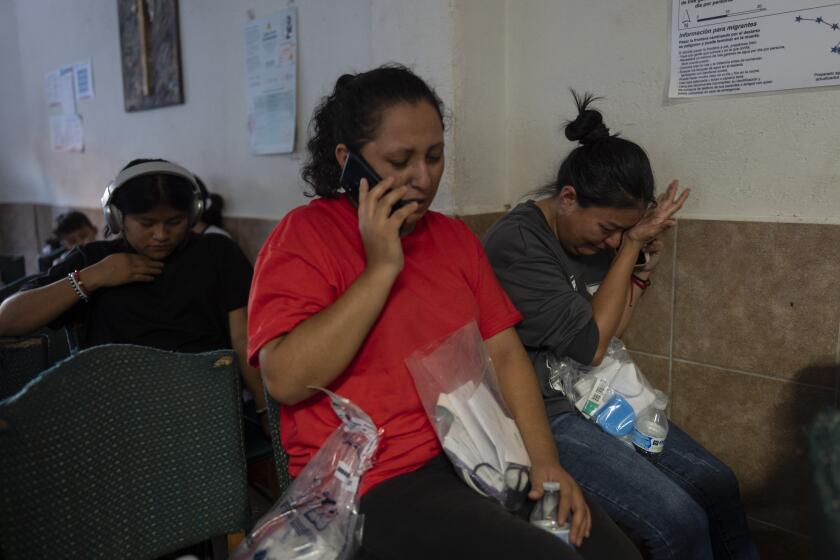 Con una bolsa en la mano entregada por la Patrulla Fronteriza con sus pertenencias, la migrante mexicana Ana Ruiz, a la derecha, se enjuga las lágrimas mientras habla con un familiar en el refugio San Juan Bosco en Nogales, México, el martes 25 de junio de 2024, tras ser deportada a su país desde Estados Unidos. La suspensión del asilo, que entró en vigencia el 5 de junio y ha supuesto una reducción del 40% en las detenciones de cruces ilegales, se aplica a todas las nacionalidades. Pero afecta especialmente a las que tienen más opciones de deportación, en concreto a los mexicanos y otras personas a las que México acepta recibir (AP Foto/Jae C. Hong)