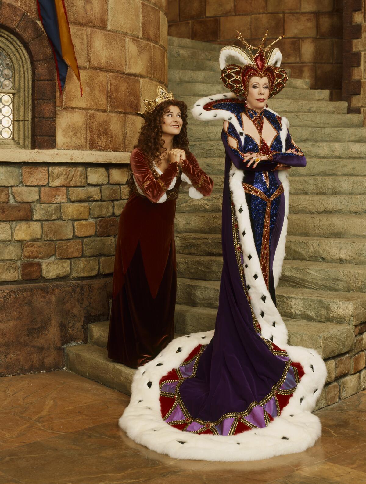 A princess and queen stand on a staircase.