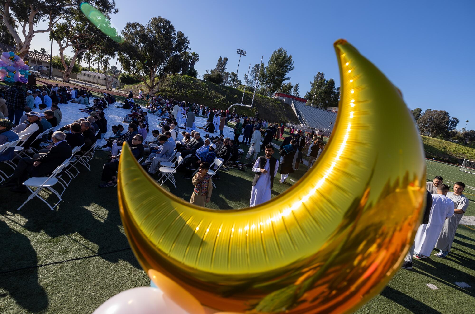 The faithful gather for the Islamic Society of West Valley's Eid celebration at the Pierce College football stadium.