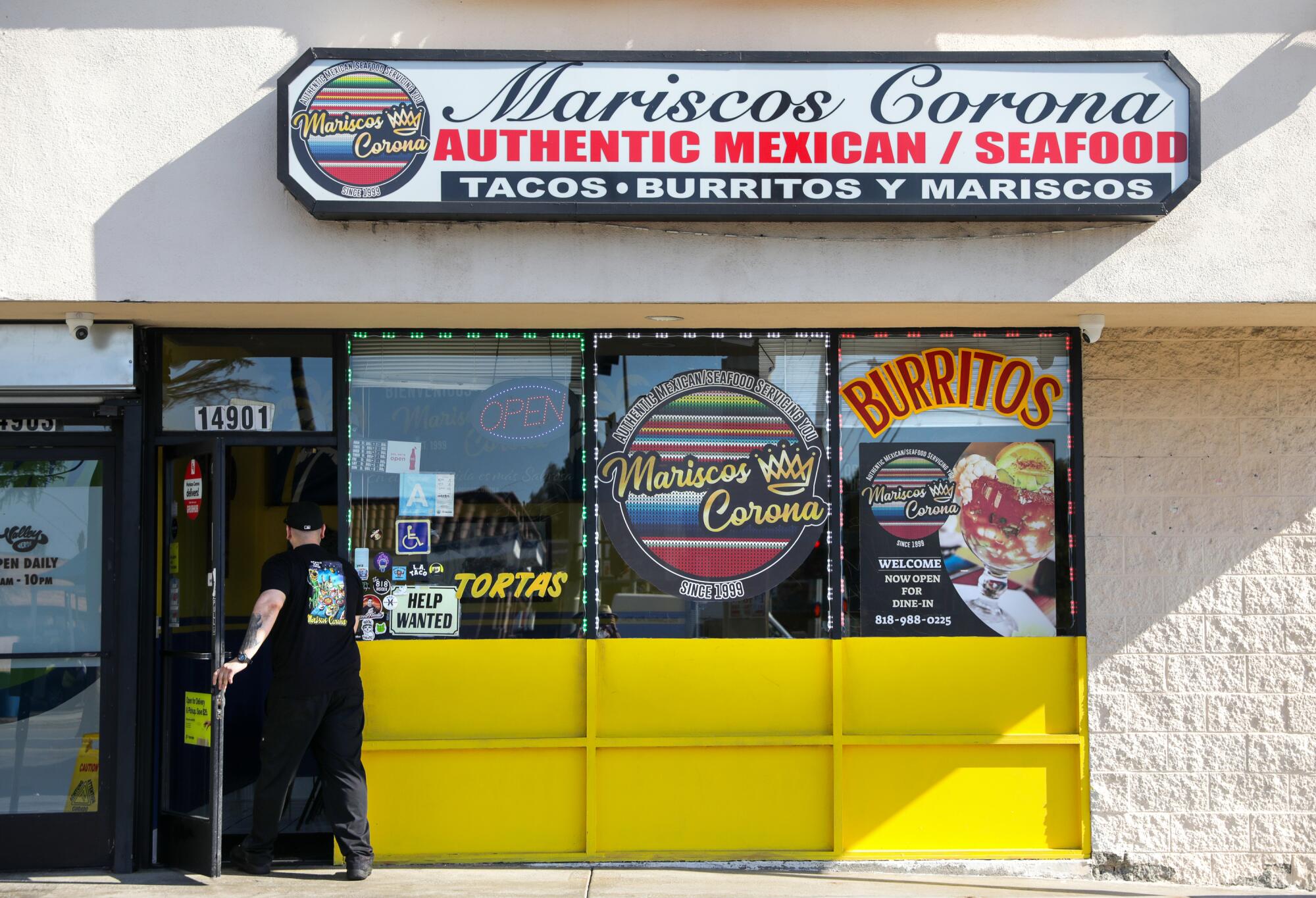 A person walks through the door into Mariscos Corona