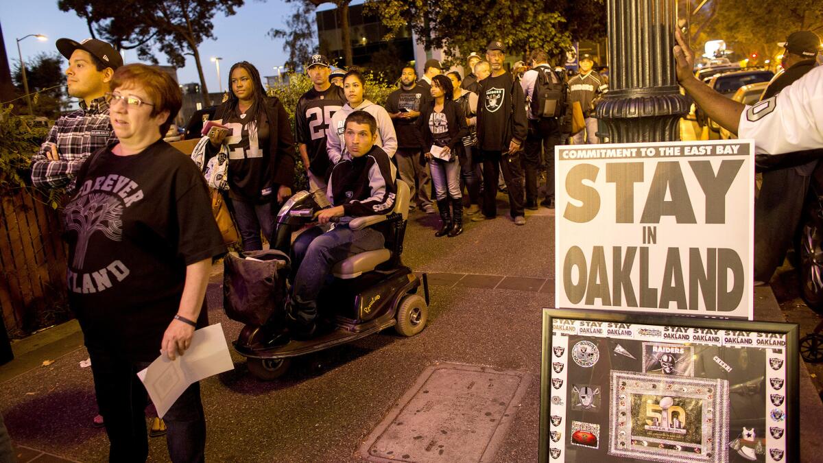 Raiders fans wait in line to enter a hearing with NFL executives at Paramount Theatre in Oakland regarding the possible relocation of the team to L.A.