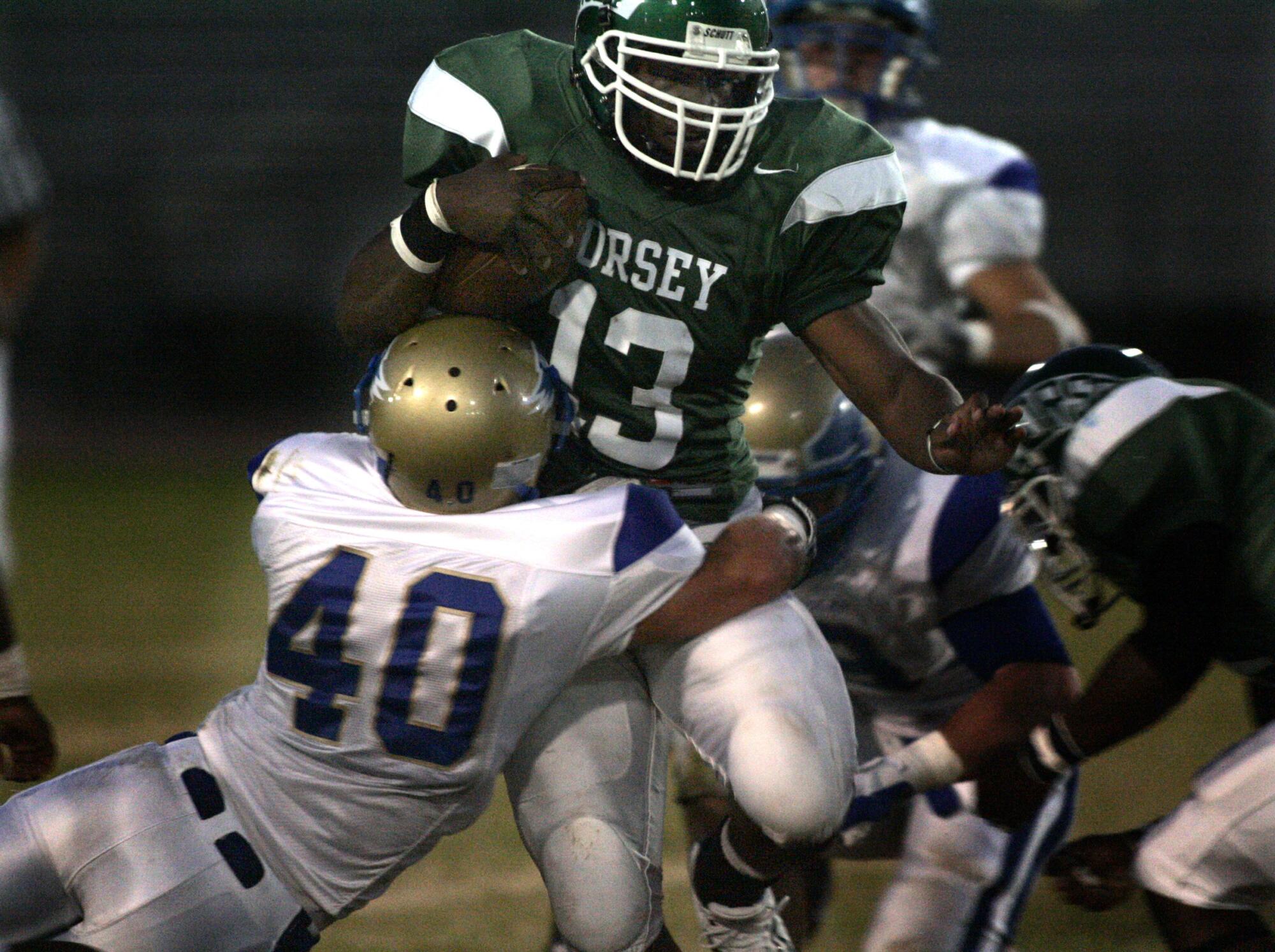 Stafon Johnson is tackled by Santa Margarita's DJ Dawson while playing for Dorsey.