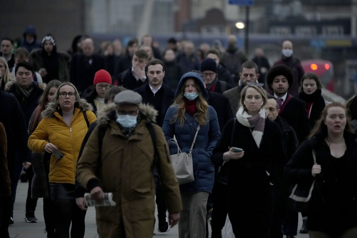 People walk outside in London, mostly without face masks.