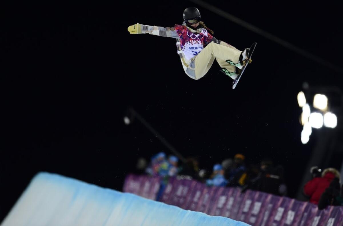 Kaitlyn Farrington grabs her board during a jump on her way to a gold medal.
