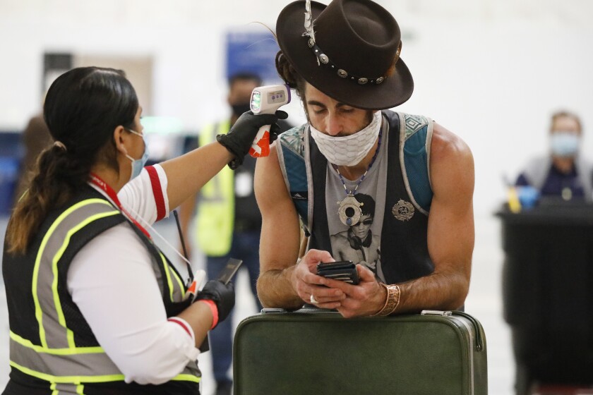 A passenger at Los Angeles International Airport has his temperature checked before being allowed to fly on Nov. 16, 2020. 