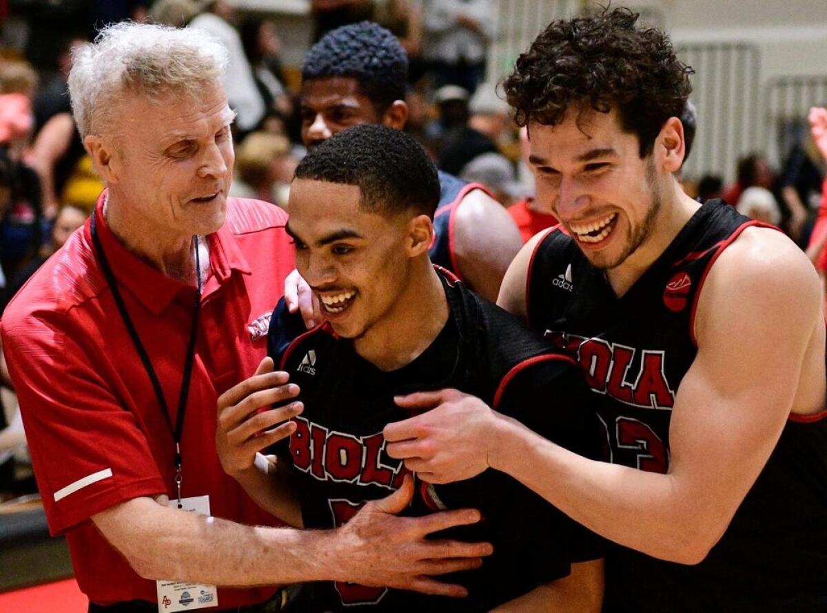 Biola University coach Dave Holmquist celebrates with players during a recent game.