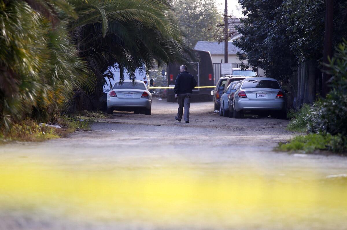 Montclair police homicide detectives search for evidence along a long driveway, where two men were found dead Sunday night in the garage with their wrists bound with duct tape.