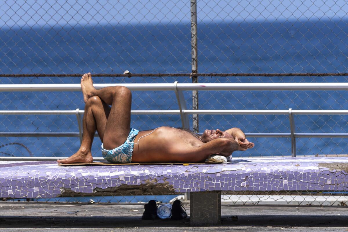 Un hombre toma el sol en malecón de Beirut,