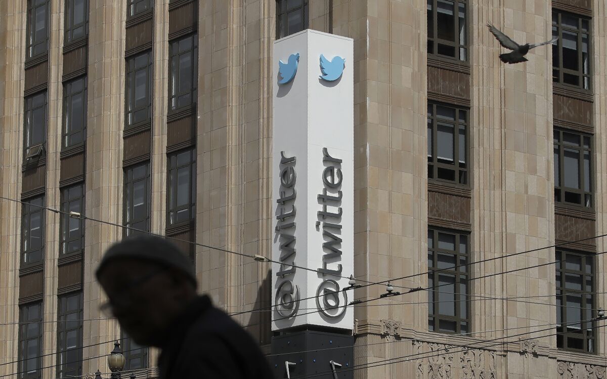 FILE - In this July 9, 2019, file photo a pedestrian walks across the street from the Twitter office building in San Francisco. A complaint unsealed in a federal court detailed a coordinated effort by Saudi officials to recruit employees at the social media giant who could tap into the Twitter accounts of political opponents and access their personal data, including internet protocol addresses that can give up a user's location. (AP Photo/Jeff Chiu, File)