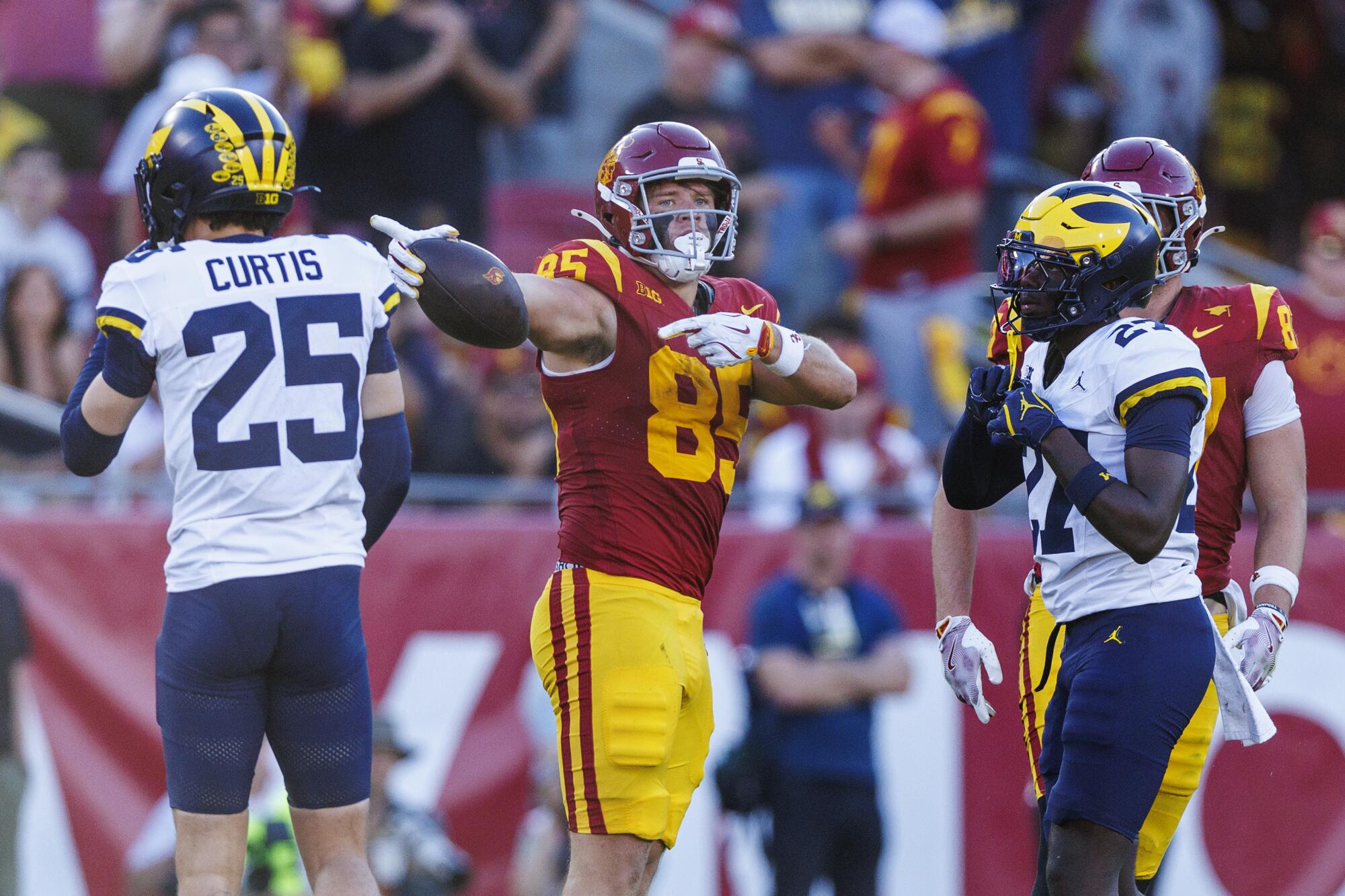 El ajustado de la USC, Walker Lyons, hace un gesto de primera dirección después de atrapar un pase contra Michigan en el Coliseo.