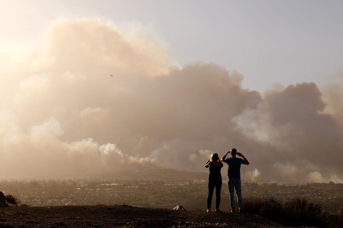 Derek and Linda Oliver watch smoke from the fast-moving Hill fire fill the skies in Thousand Oaks the afternoon of Nov. 8.