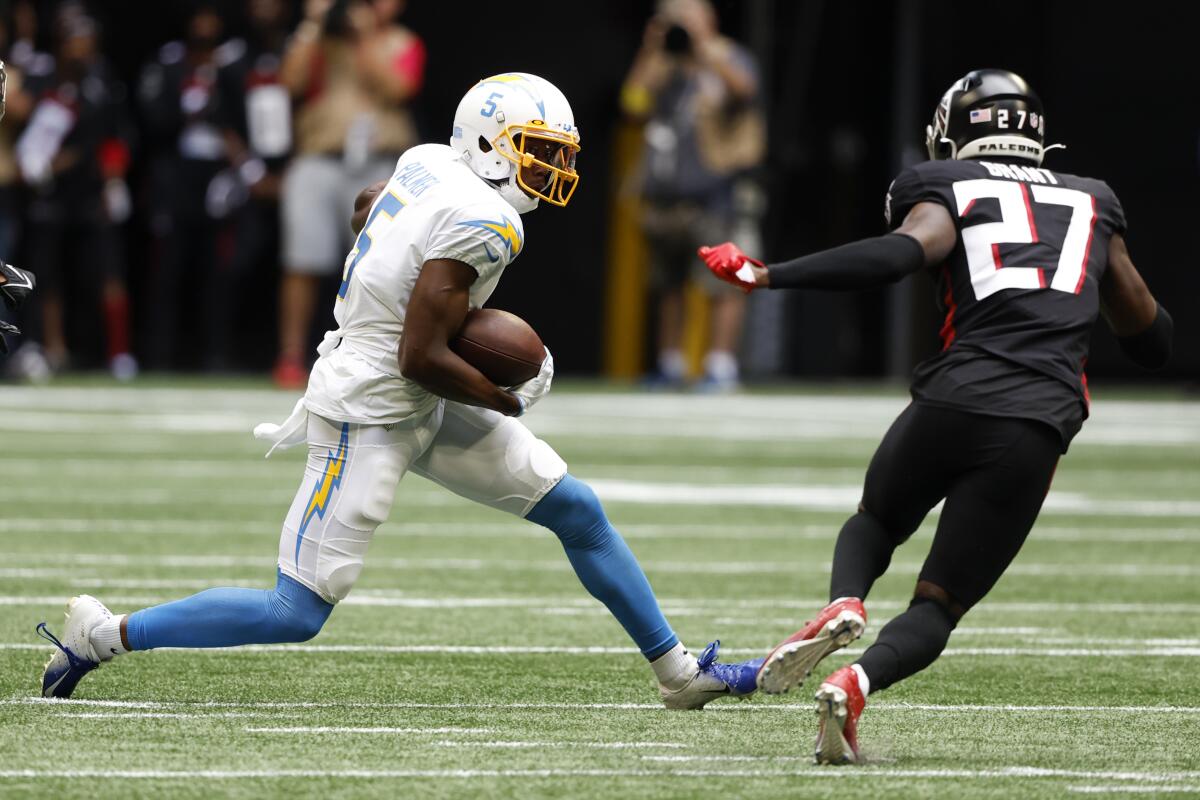 Chargers wide receiver Joshua Palmer (5) tries to allude Falcons safety Richie Grant (27) after catching a pass.