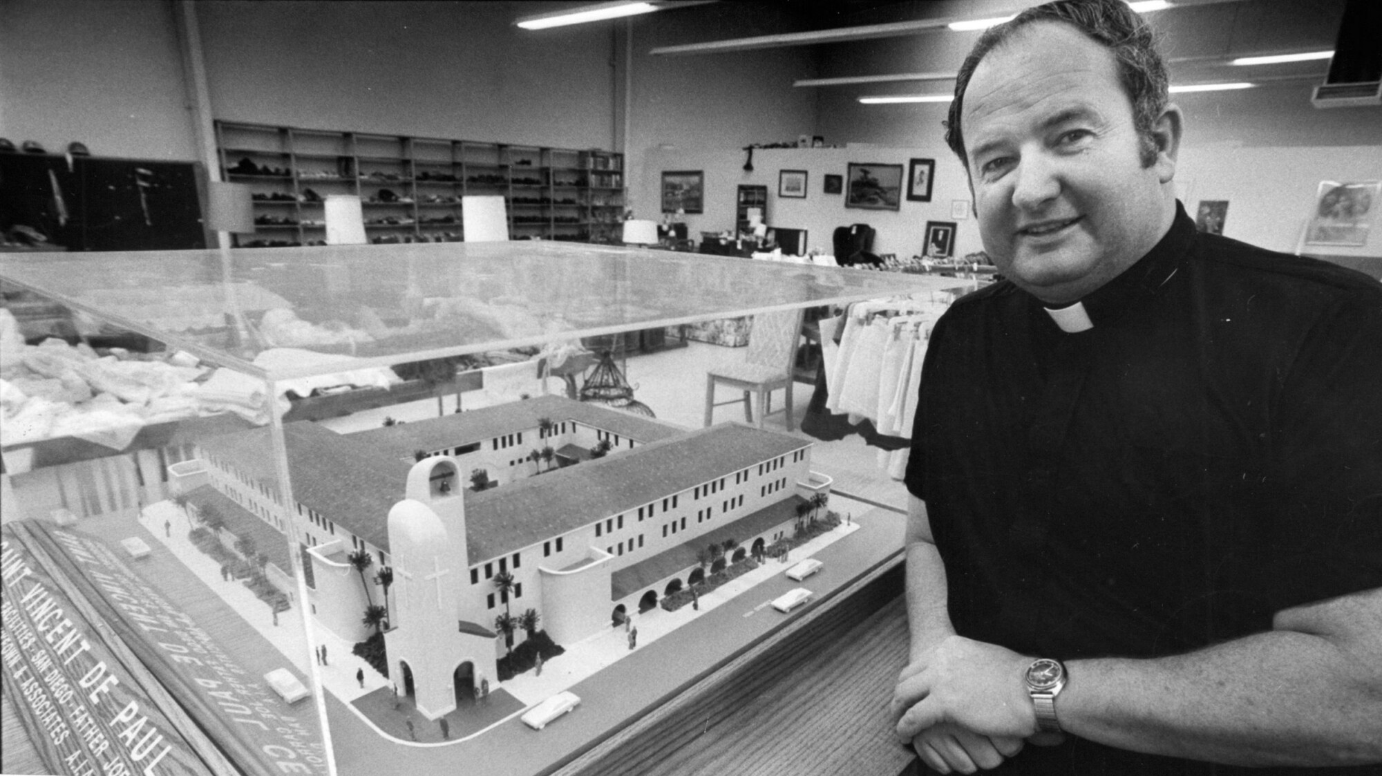 Father Joe Carroll stands with a model of the St. Vincent de Paul Center