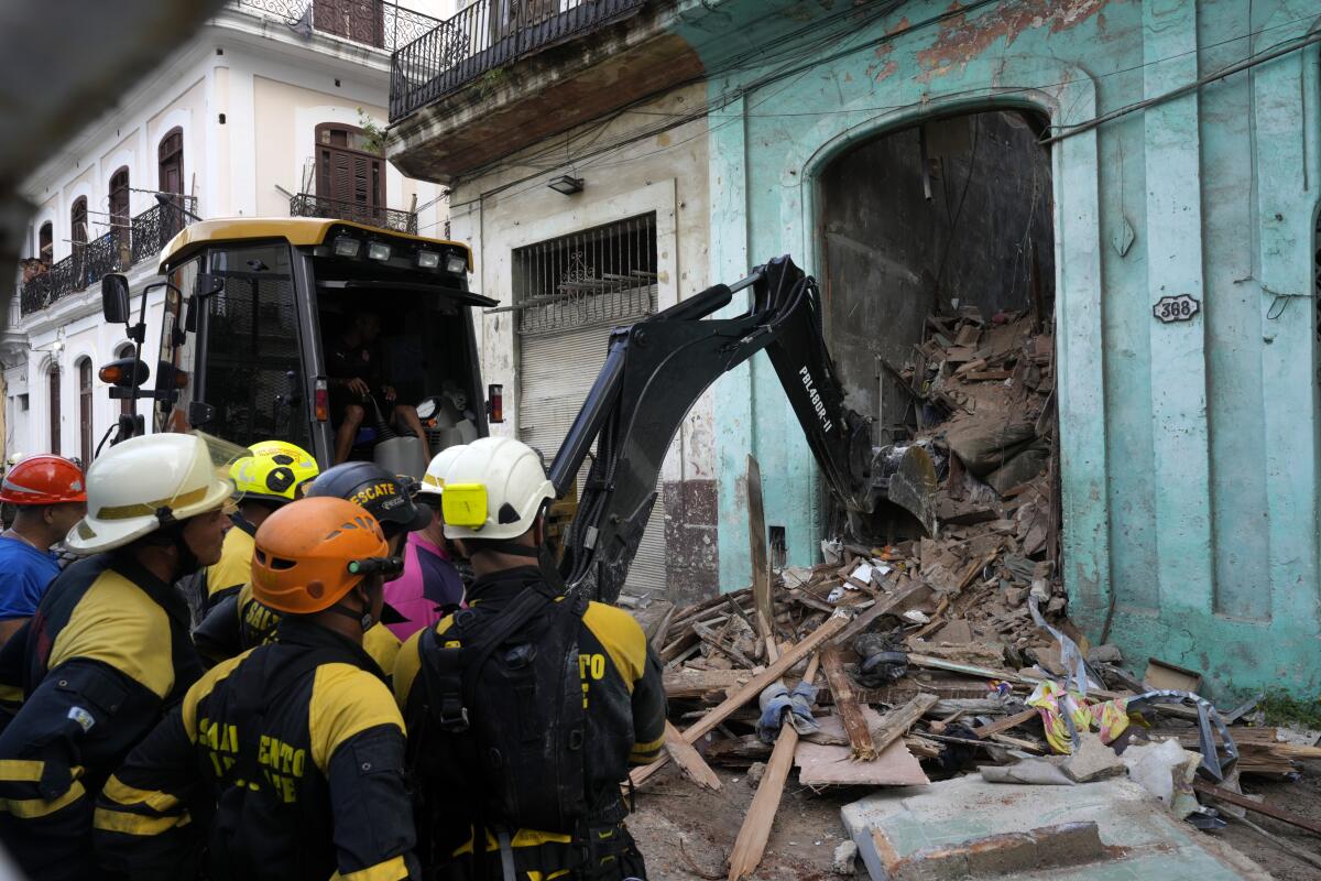Los bomberos retiran los escombros de un edificio que se derrumbó parcialmente en La Habana, Cuba, 
