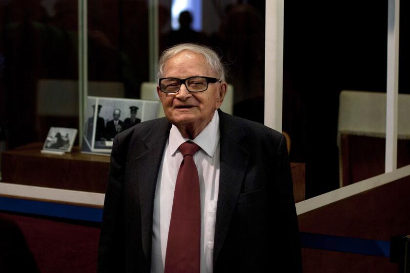 FILE - In this Monday, Dec. 12, 2011 file photo, Israeli Rafi Eitan, right, stands next to a showcase during an opening of an exhibition about Eichmann's capture at the Knesset, Israel's parliament in Jerusalem. Eitan, a legendary Israeli Mossad spy who led the capture of Holocaust mastermind Adolf Eichmann, has died. He was 92. (AP Photo/Sebastian Scheiner)