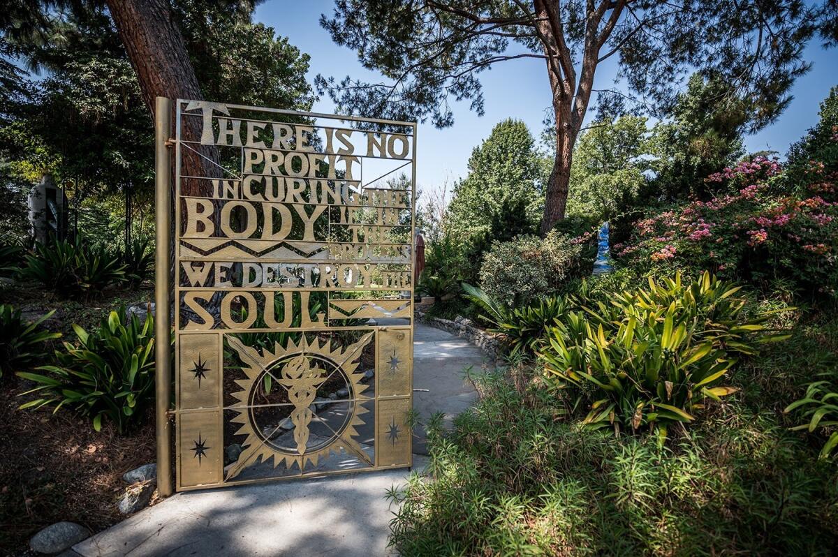 A gate on the campus of City of Hope surrounded by greenery.