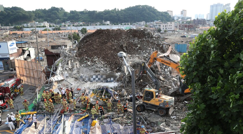 Firefighters search for survivors following a collapsed building in Gwangju, South Korea, Wednesday, June 9, 2021. A building being demolished in southern South Korea collapsed on Wednesday, sending debris falling on nearby vehicles and seriously injuring several people, officials said(Chung Hoi-sung/Yonhap via AP)
