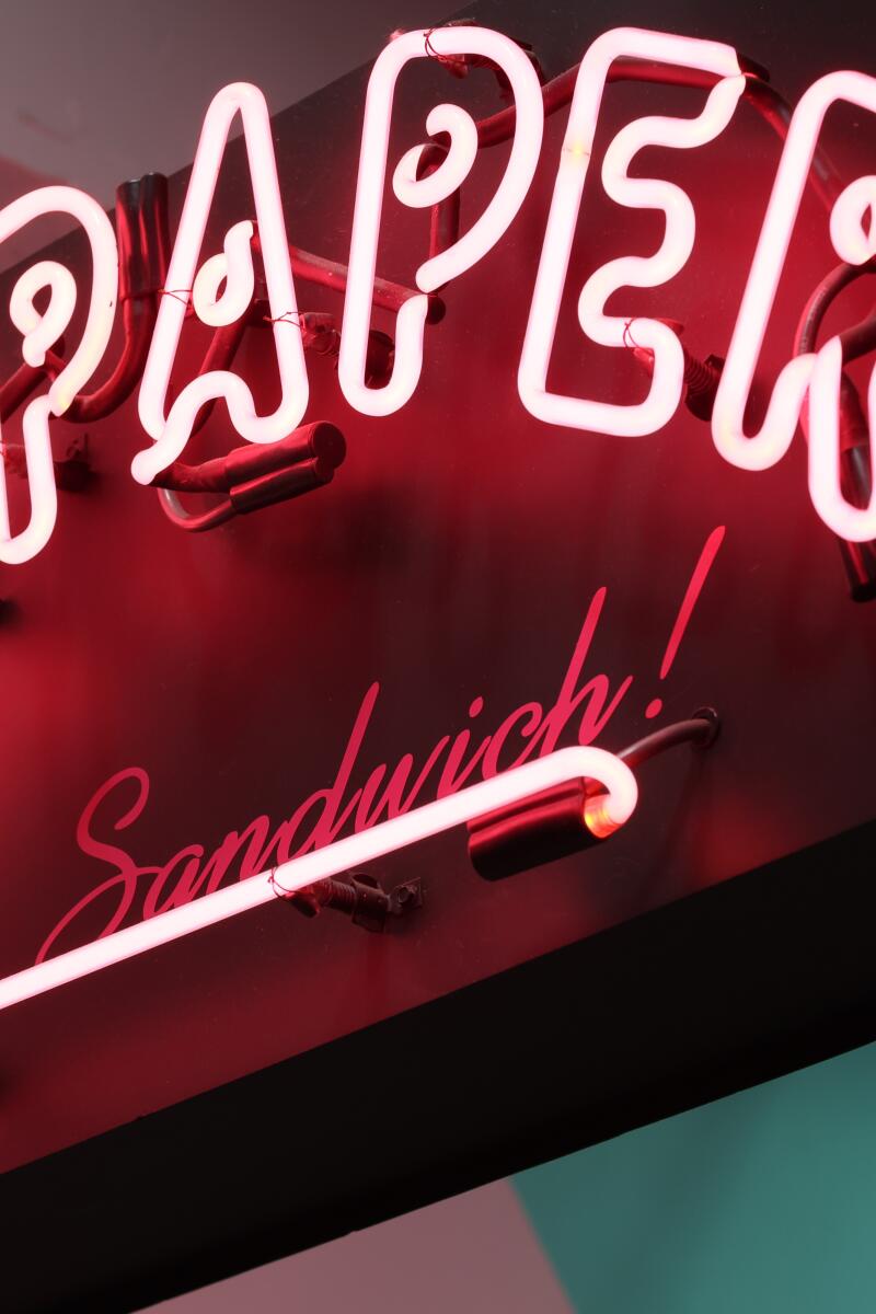A neon sign that says Wax Paper It's a Sandwich!