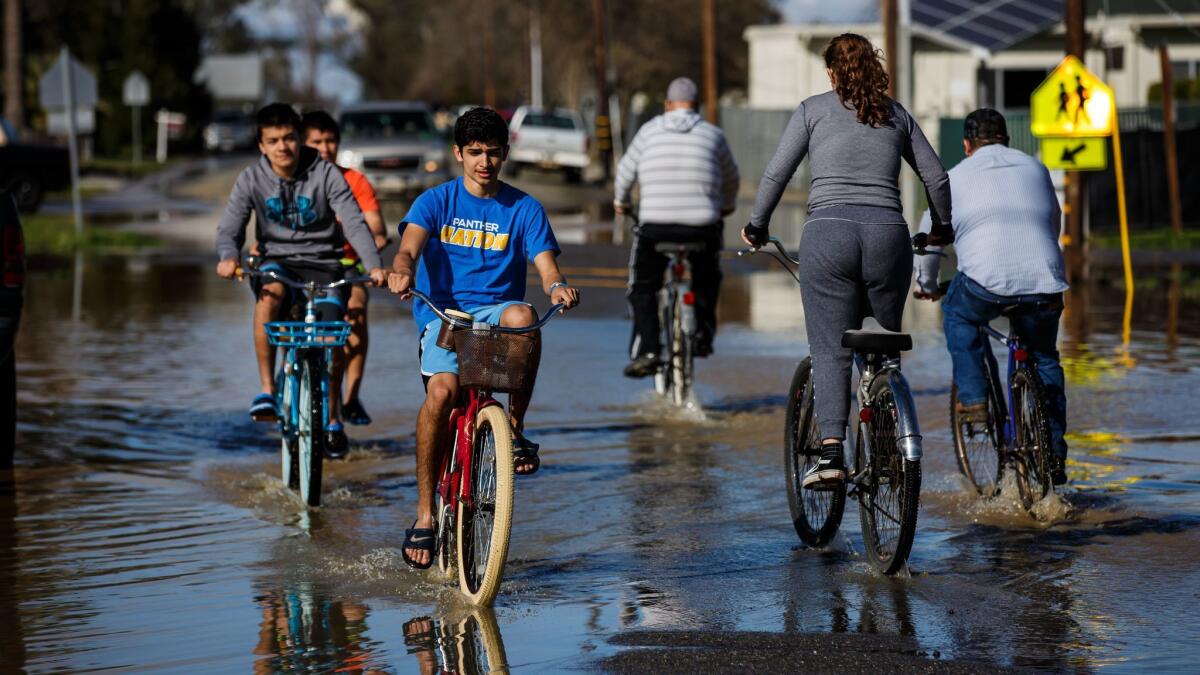 As floodwaters recede Saturday, residents get out for a ride in Maxwell, about 50 miles from Oroville.