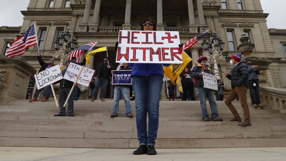 Protesters outside the Michigan Capitol on Wednesday show their displeasure with Gov. Gretchen Whitmer's stay-at-home order. Some of the protesters carried guns.