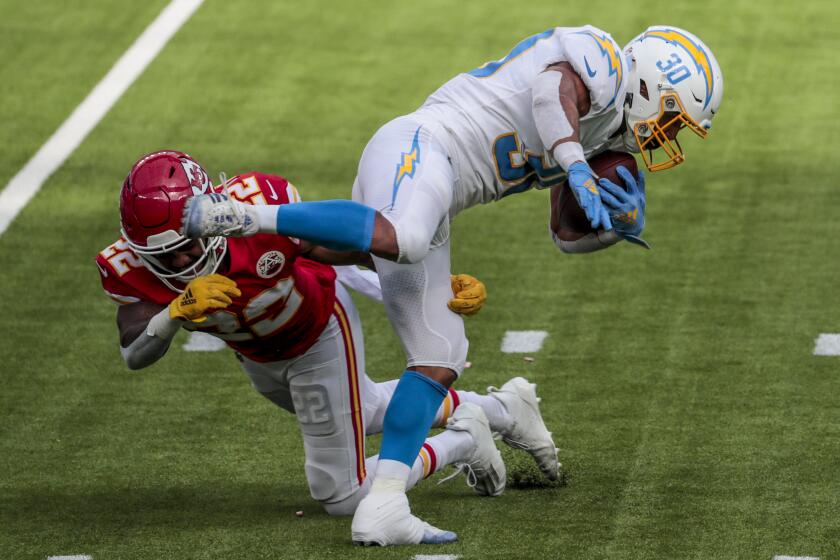 Inglewood, CA, Sunday, September 20, 2020 - Running back Austin Ekeler #30 of the Los Angeles Chargers slips the tackle of safety Juan Thornhill #22 of the Kansas City Chiefs during second half action at SoFi Stadium. (Robert Gauthier/ Los Angeles Times)