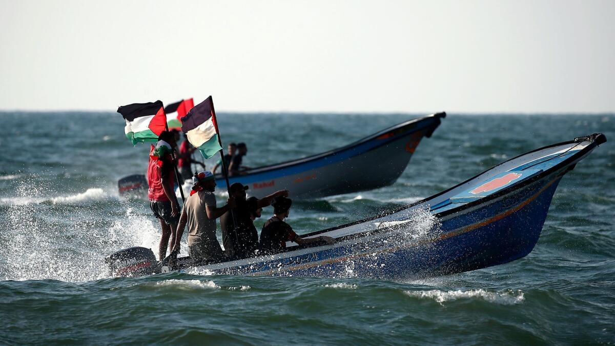 Palestinians steer their boat as they protest against Israel's naval blockade of Gaza, in Beit Lahia on the border with Israel in the northern Gaza Strip on Aug. 11, 2018.