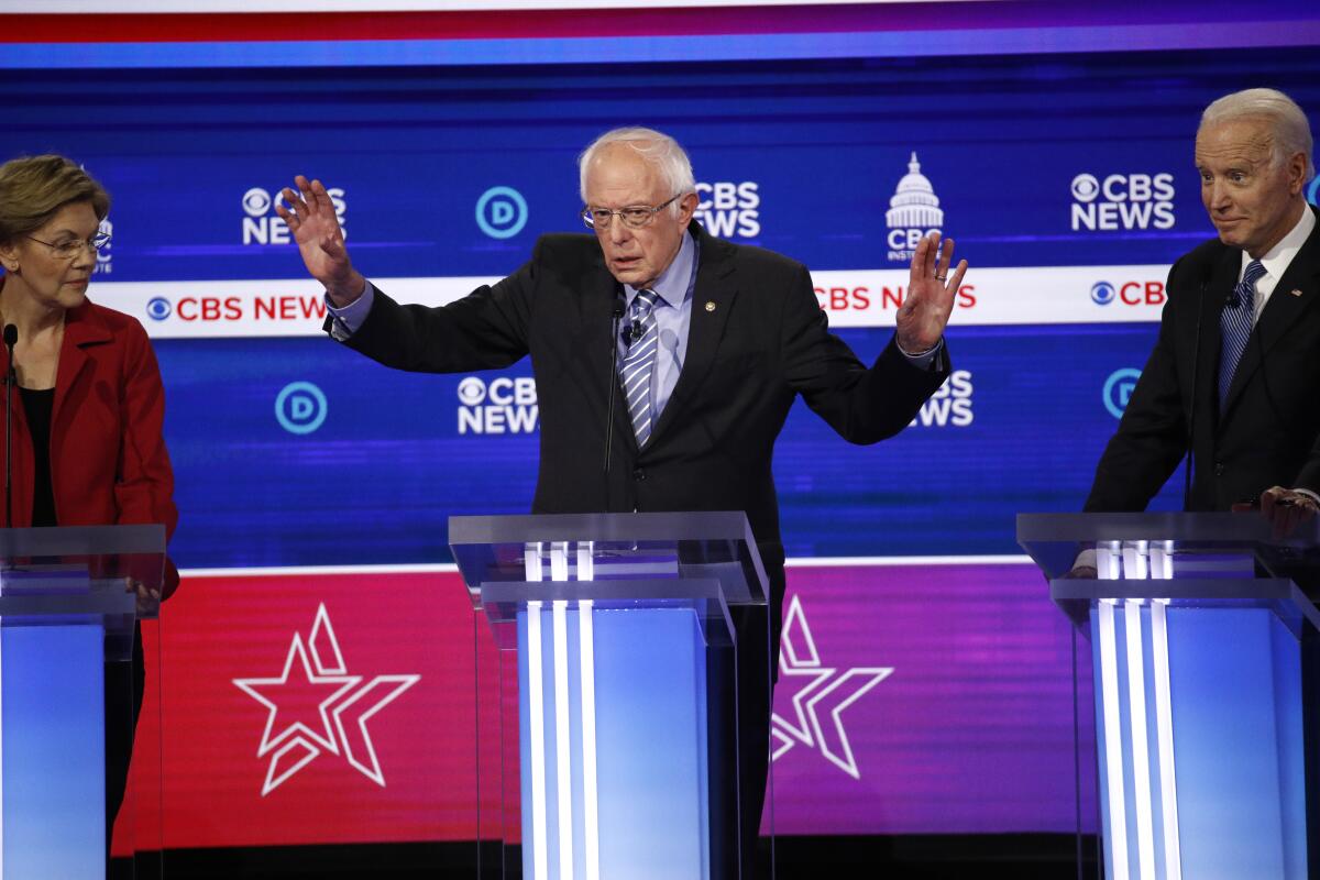 Bernie Sanders, flanked by Elizabeth Warren and Joe Biden, speaks during Tuesday’s debate in Charleston, S.C.