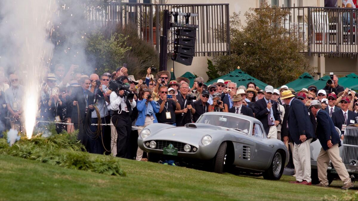 Fans and judges watch a 1954 Ferrari 375 MM Scaglietti Coupe drive up to accept the Best of Show award in 2014.