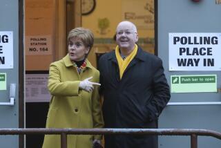 FILE - Scottish First Minister Nicola Sturgeon poses for the media with husband Peter Murrell, outside polling station in Glasgow, Scotland, on Dec. 12, 2019. British media are reporting that the husband of former Scottish National Party leader Nicola Sturgeon has been arrested in a party finance probe on Wednesday, April 5, 2023. (AP Photo/Scott Heppell, File)