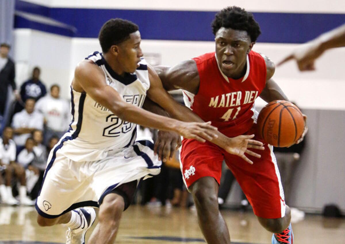 Mater Dei senior Stanley Johnson drives down the lane against Mayfair junior Kendall Small during a Southern Section Open Division playoff quarterfinal game on Friday night in Lakewood.