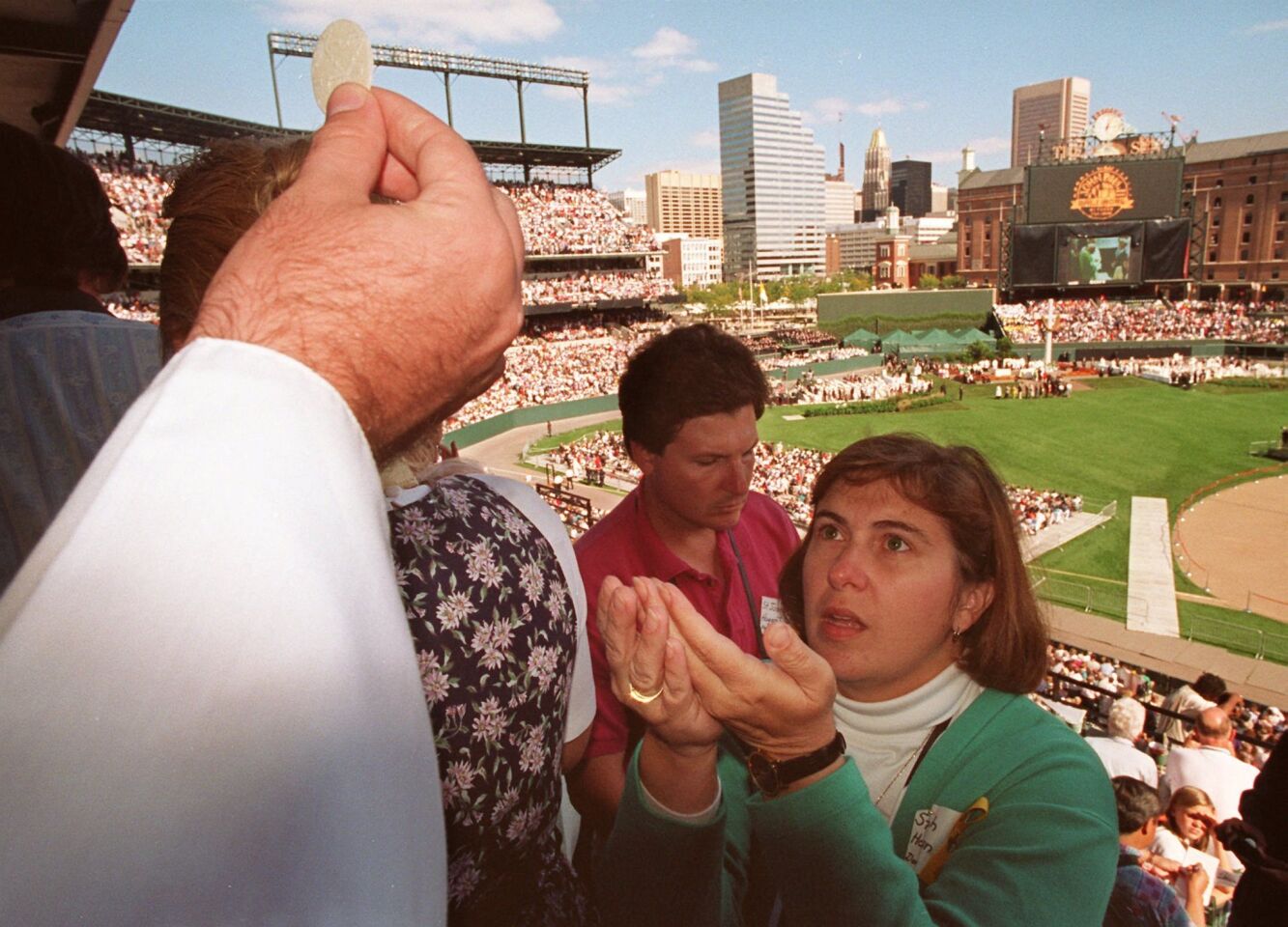 During Pope John Paul II's visit to Baltimore, attendees at a papal Mass in Camden Yards receive Communion.