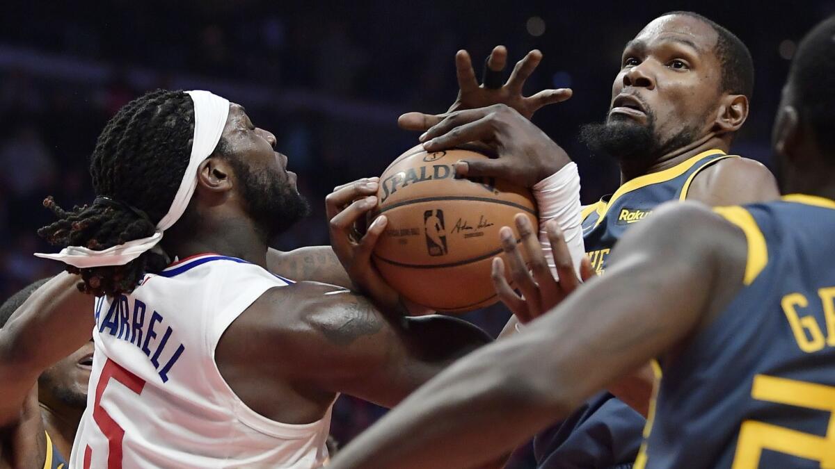 Clippers' Montrezl Harrell, left, and Golden State' Kevin Durant grapple for the ball.