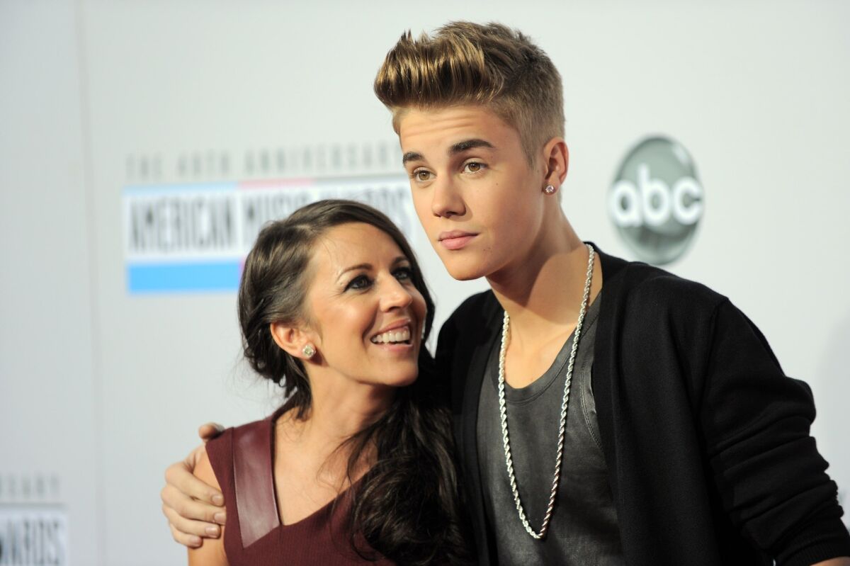 Justin Bieber, right, and his mother Pattie Mallette arrive at the 40th anniversary American Music Awards.