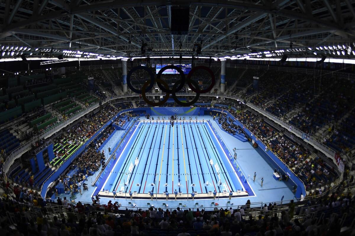Swimmers take part in a men's 400-meter individual medley preliminary heat on Saturday at the Olympic Aquatics Stadium.